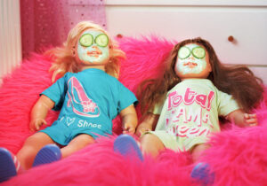 two-dolls-lying-down-with-face-cream-and-cucumber-on-their-eyes.