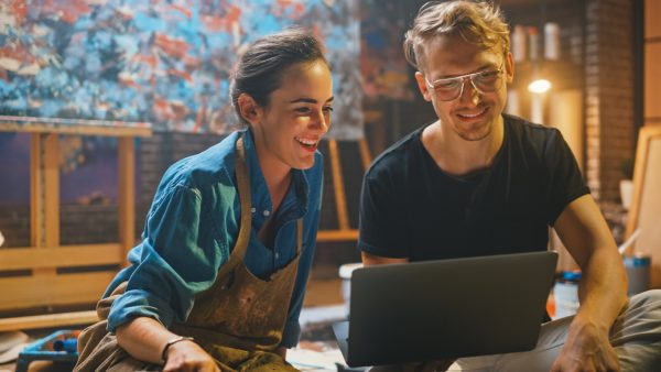 couple-of-artists-sitting-in-their-studio-use-laptop