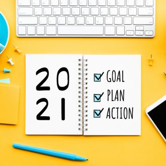new year goals for artists checklist - yellow table-pen-pencil-smartphone-cup-of-coffee-white-keyboard