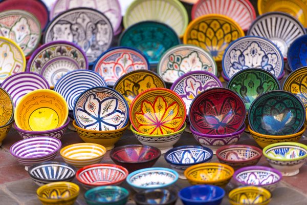 decorate bowls nested in a colorful display in a stall at an artisan market