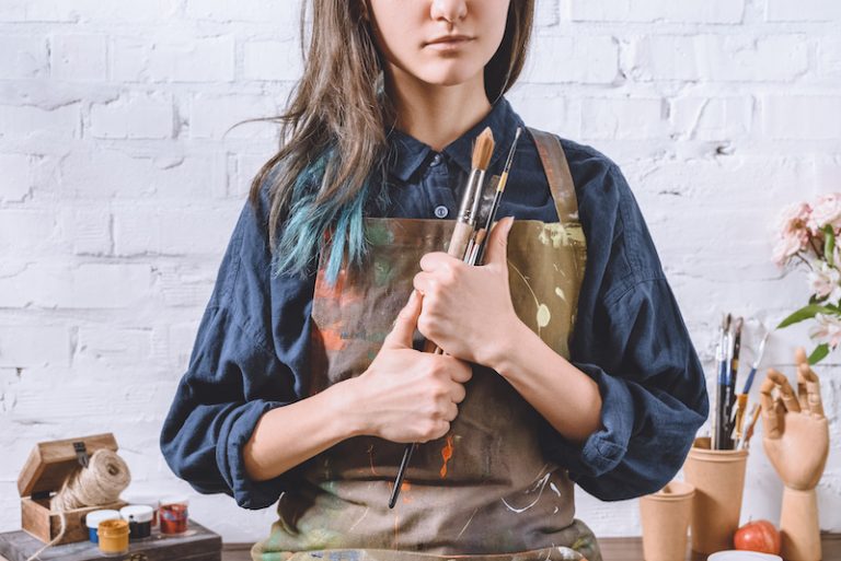 cropped-image-of-female-artist-holding-brushes