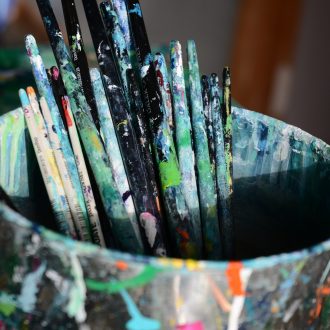 Cropped-shot-of-a-tin-full-of-paintbrushes-in-an-empty-art-studio