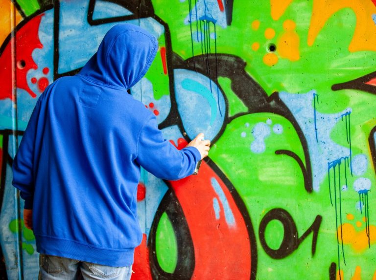 artist writing graffiti on wall
