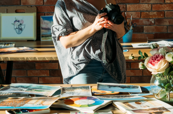 artist taking photos on her paintings in studio