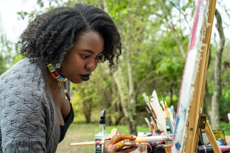 Black woman artist painting en plein air