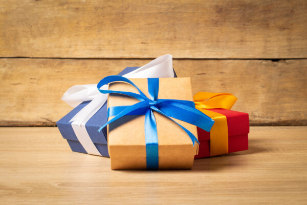 Three solid color Christmas gift boxes with a simple ribbon bow.