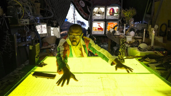 Man leaning over a yellow glowing desk