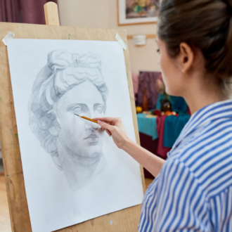 woman drawing on an easel in a bright studio
