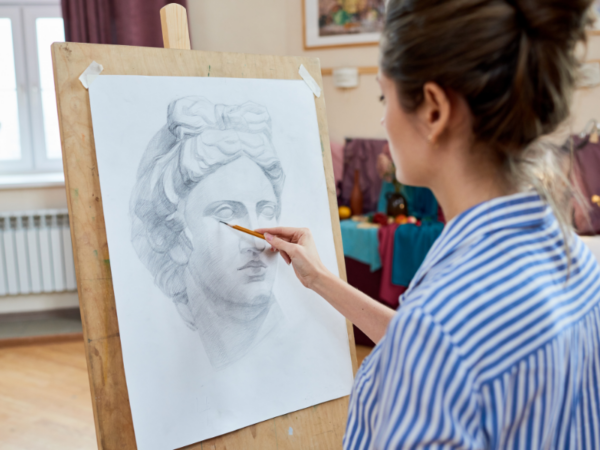 woman drawing on an easel in a bright studio